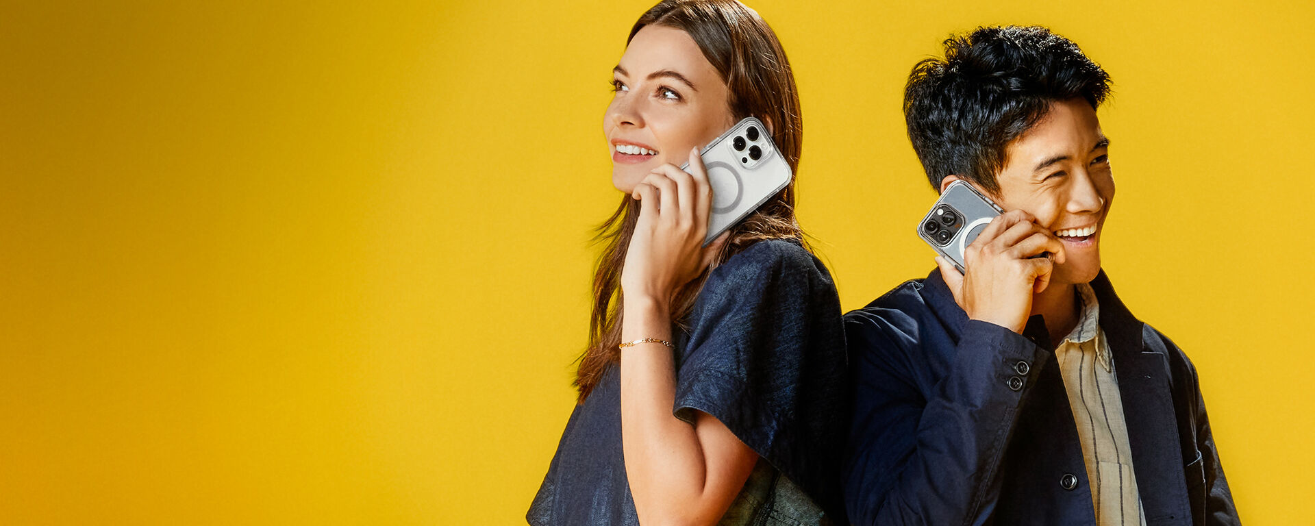 Man and woman talking on iPhones in clear Otterbox phone cases, on yellow background