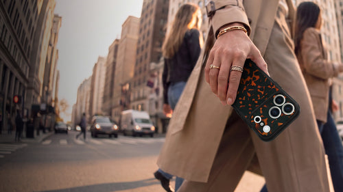 Woman carrying iPhone 18 Pro Max with a tortoise shell OtterBox case