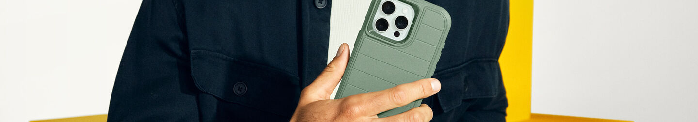 Man holding green OtterBox Defender Series iPhone case