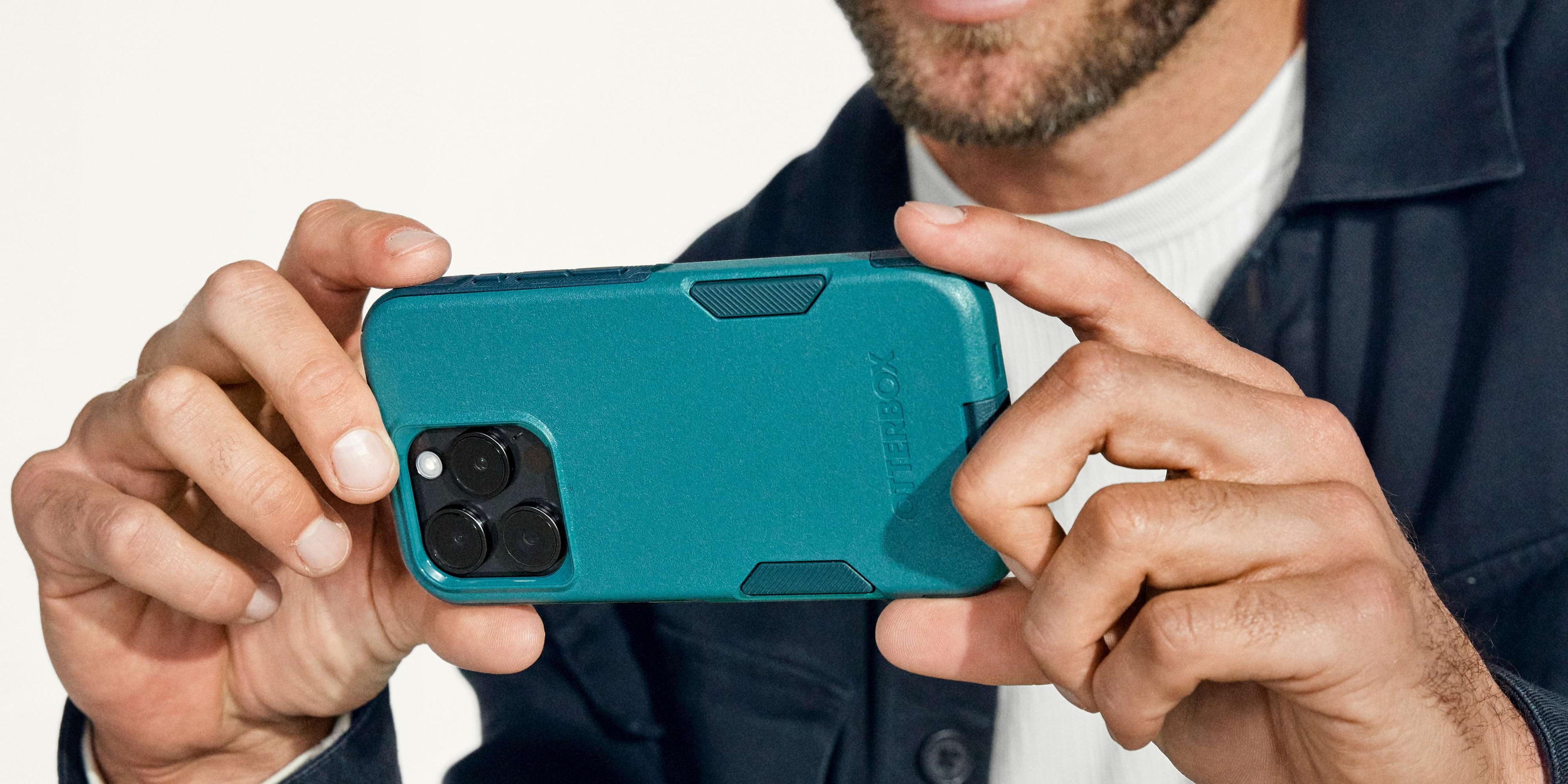 man taking a picture on iphone 16 in green otterbox commuter series phone case
