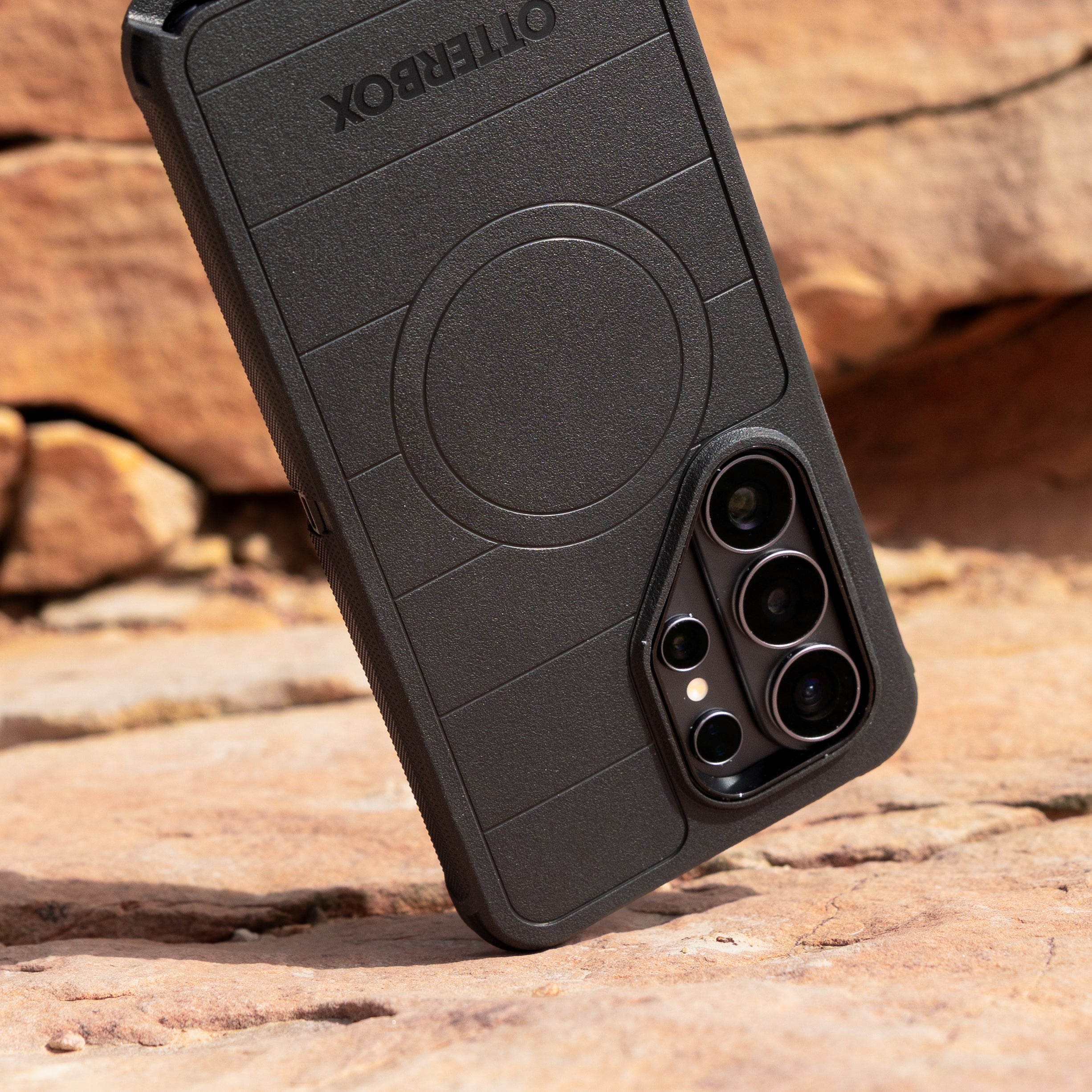 Black defender phone case with OtterBox  branding on a rocky surface