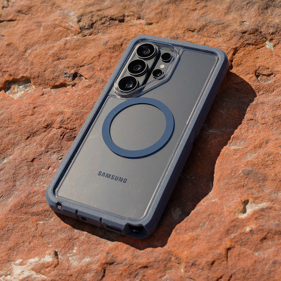 Blue Samsung Defender XT phone case on a rocky surface.