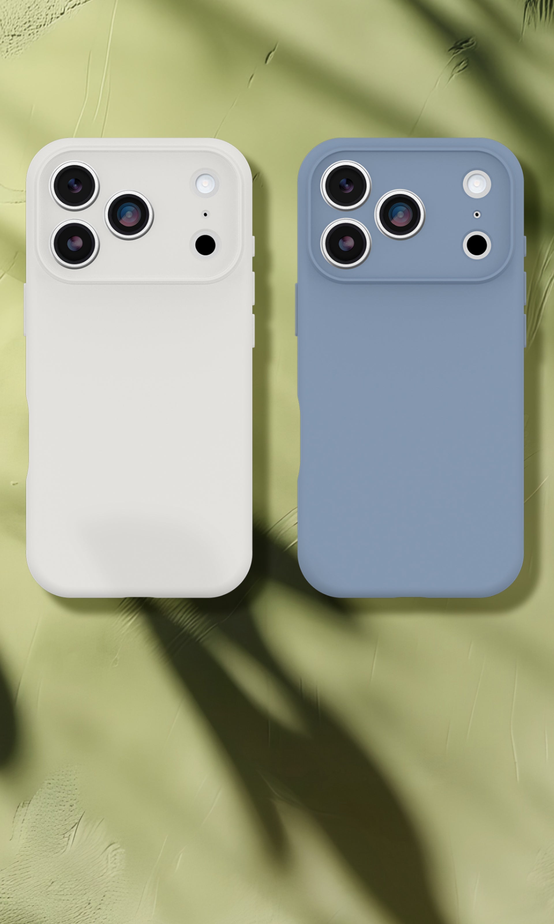 Two phone cases, one white and one blue, on a green leafy background.