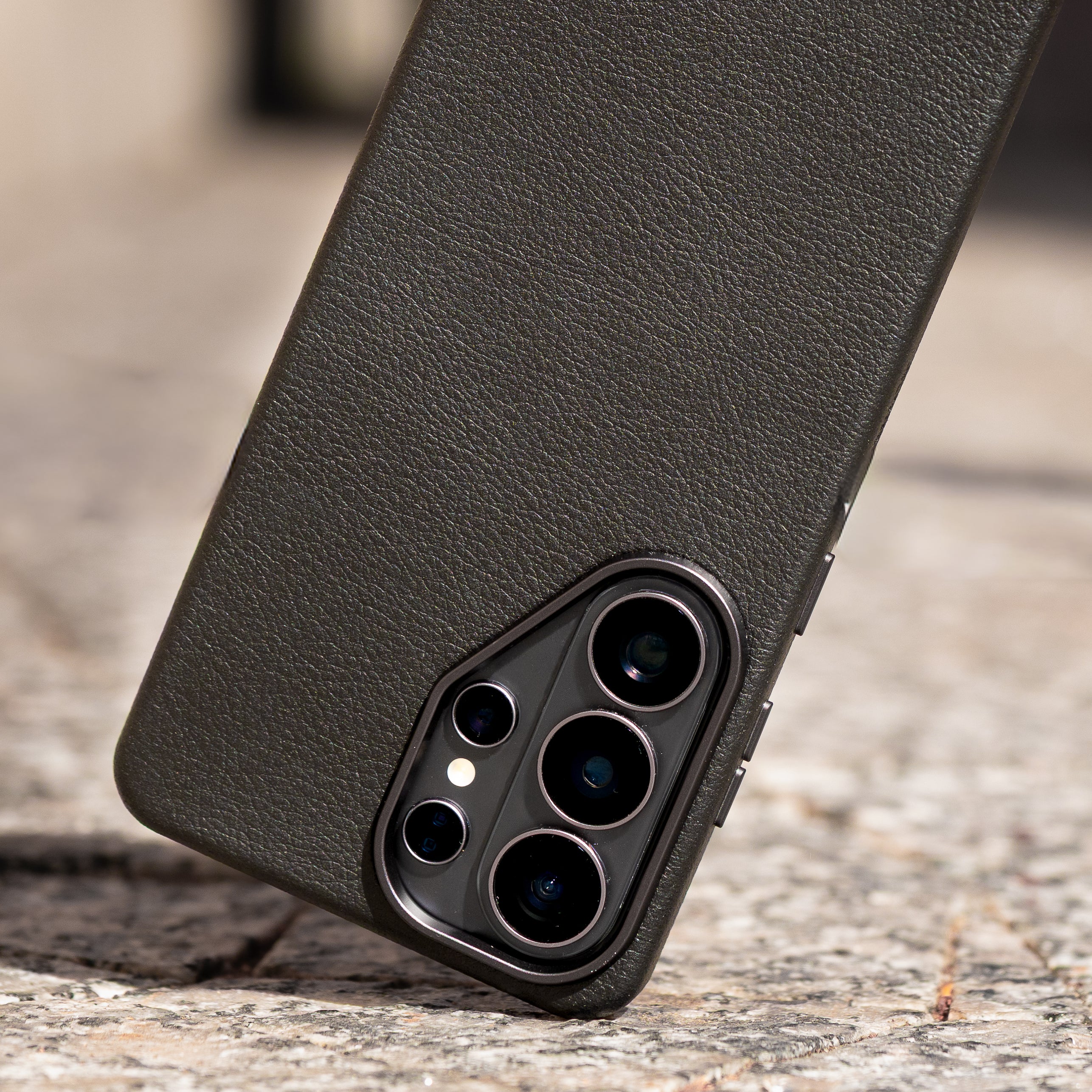 Black faux leather phone case on a textured surface