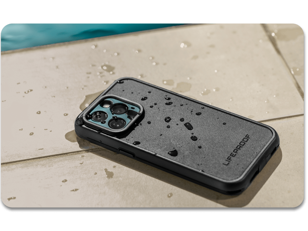 Phone case with water droplets on a wooden surface near a pool