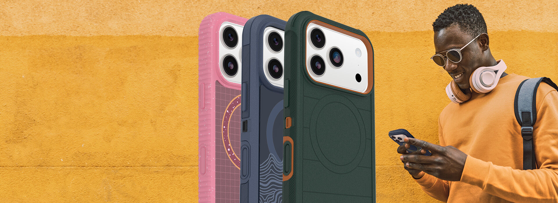 man smiling and holding new iphone 17 series with colorful phone cases on an orange background