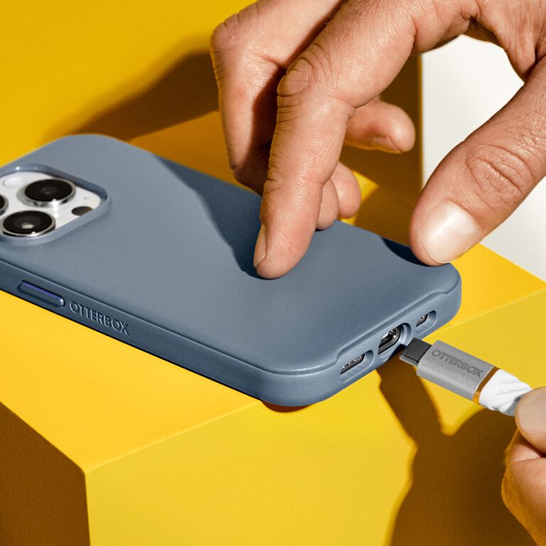 plugging charging cable into iPhone with blue case